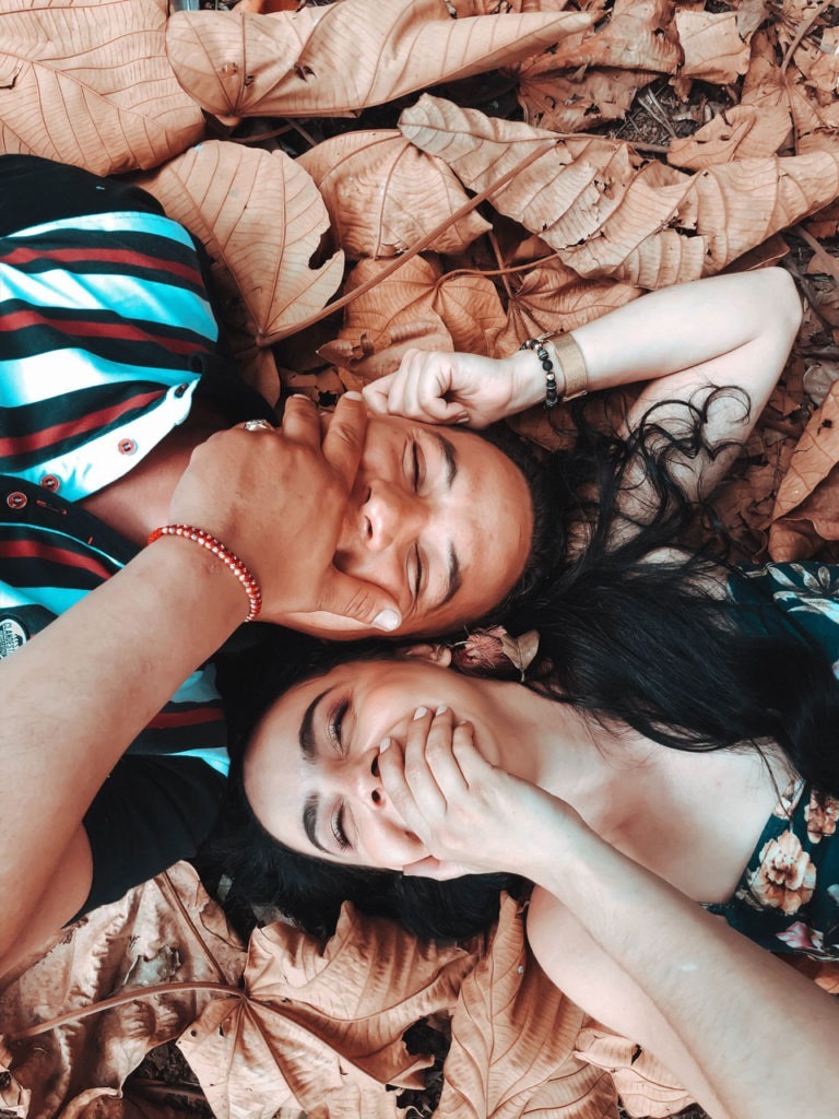 Couple Smiling With Their Hands Covering The Mouth