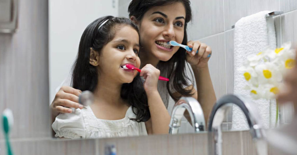 Mom and daughter brushing their teeth