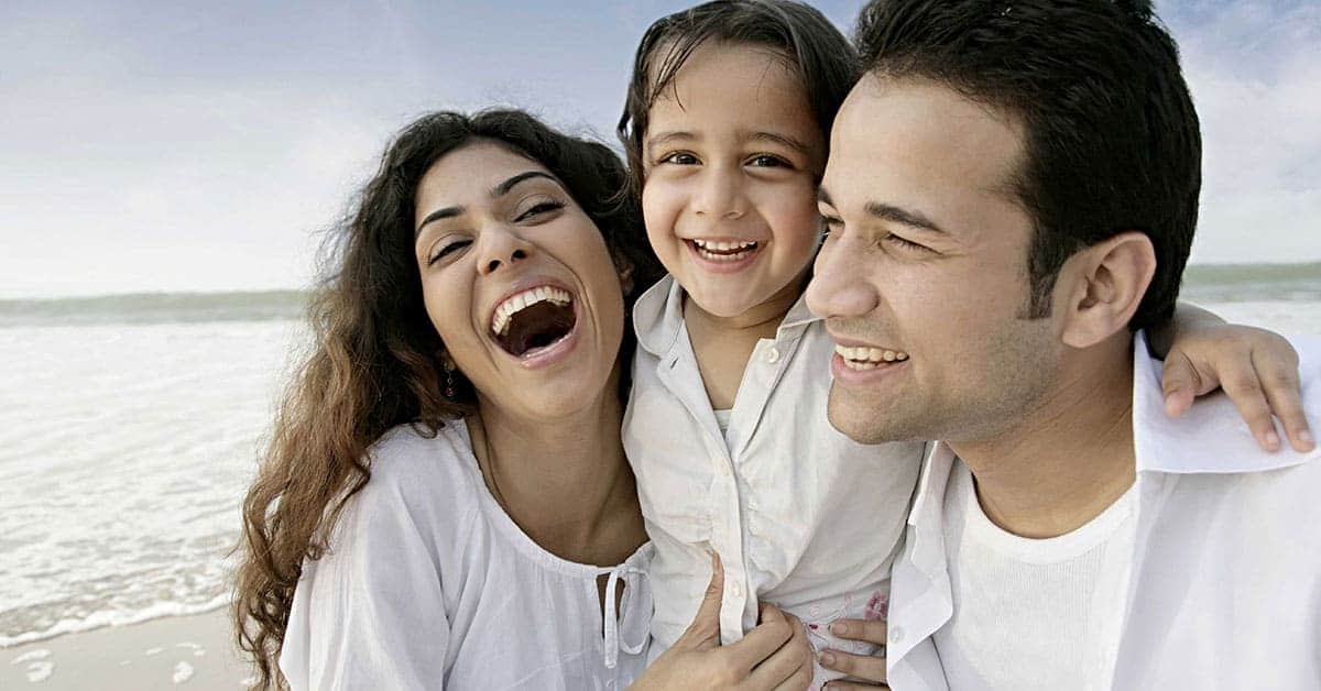 A family of dad, mom and child smiling